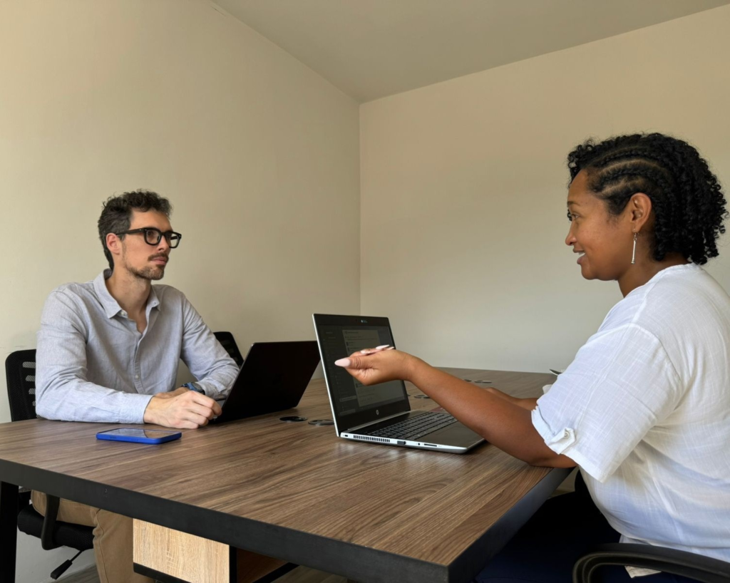 Deux professionnels de ScaleMyCrew échangent sur les ressources humaines lors d’une réunion de travail.